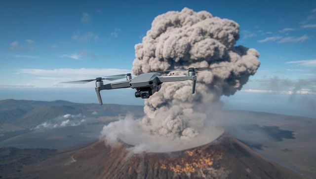 Drone capturing volcanic eruption with massive ash plume over crater