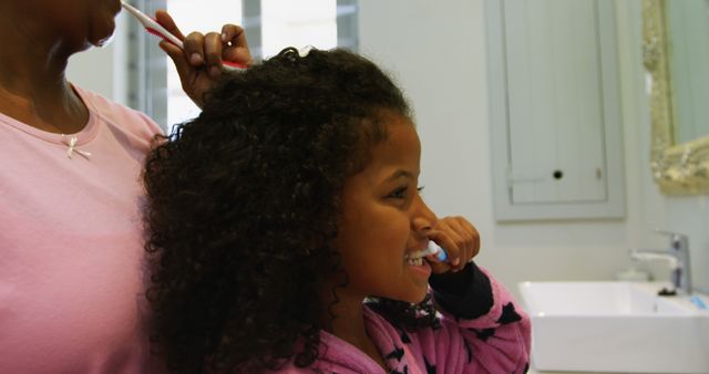 Mother Brushing Daughter's Hair While Daughter Brushing Teeth in Bathroom - Download Free Stock Images Pikwizard.com