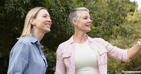 Midlife women smiling together in garden sharing moment of friendship and connection