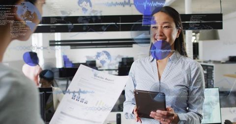 Smiling korean businesswoman holding tablet reviewing quarterly report with data overlays