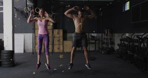 Performing explosive plyometric jumps in industrial gym by fit couple