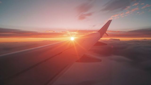Majestic Sunrise from Airplane Wing Over Clouds