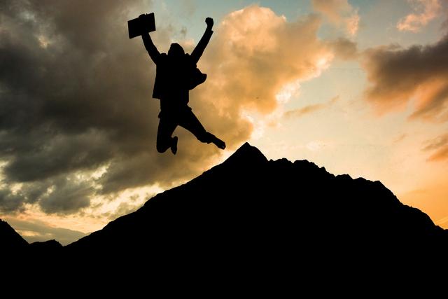 Businessman jumping with briefcase against mountain during sunset - Download Free Stock Photos Pikwizard.com