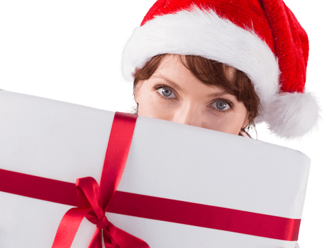 Woman hiding behind large christmas gift with ribbon and red hat