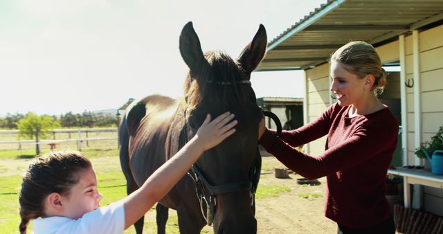 A Caucasian woman and a young girl are gently petting a horse on a sunny day, with copy space. Their interaction with the animal suggests a moment of bonding and learning about horse care.