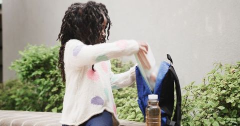 Young girl packing lunch outdoor in casual distinctive attire