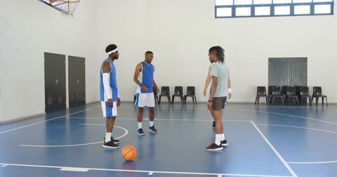 Basketball players huddling on indoor court discussing game strategy