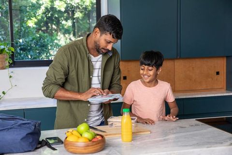 Father and son bonding while preparing lunch together in modern kitchen
