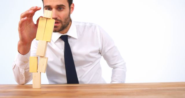 Businessman Balancing Wooden Blocks in Office - Download Free Stock Images Pikwizard.com