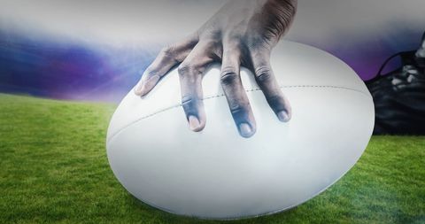 Close-Up of Hand Holding Rugby Ball on Green Grass - Download Free Stock Images Pikwizard.com