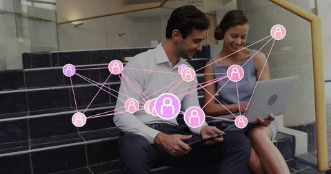 Business professionals collaborating with digital network overlay on laptop and tablet