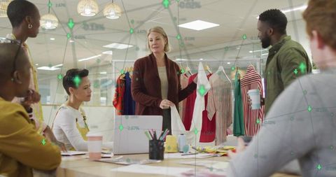 Leading fashion review presenting white garment to diverse design team in modern studio