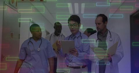 Diverse medical team reviewing patient information in hospital corridor