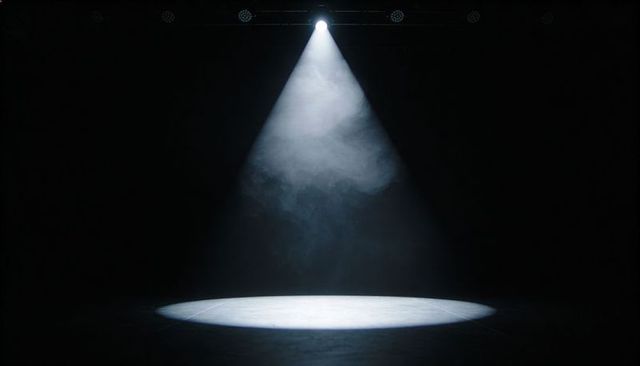Solo Spotlight Illuminating Empty Stage with Atmospheric Haze for Dramatic Theater Scenes