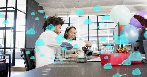 Pouring coffee in open plan office with cloud data overlay and celebratory balloons