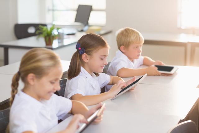 School kids using digital tablet in classroom at school