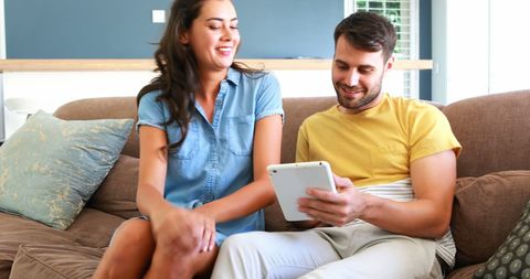 Happy Couple Enjoying Digital Tablet on Living Room Sofa - Download Free Stock Images Pikwizard.com