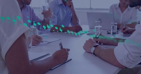 Business team taking notes and collaborating around conference table in bright workspace