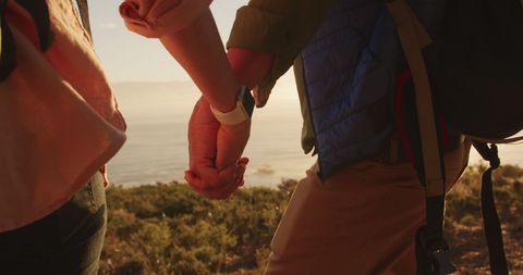 Senior Couple Holding Hands During Scenic Hike at Sunset