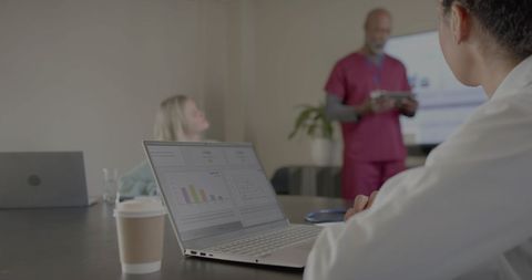 Diverse Doctors Analyzing Data in Modern Office Meeting