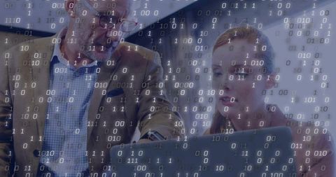 Collaborative data analysis team pointing at laptop with binary overlay for cybersecurity