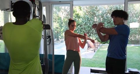 Group stretching pre-workout routine in modern home gym