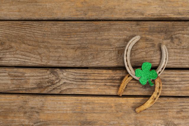 St Patricks Day shamrock with two horseshoes on wooden table