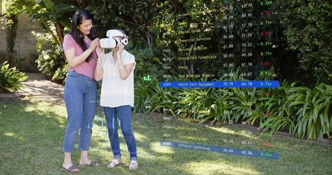 Caregiver guiding senior woman wearing vr headset in garden with augmented stock data overlay