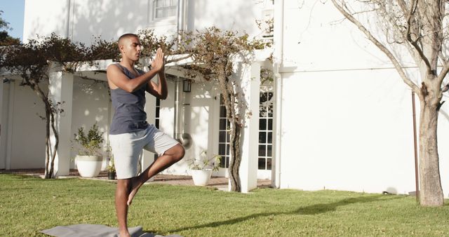 Man Practicing Tree Pose on Lawn of Sunlit Backyard - Download Free Stock Images Pikwizard.com