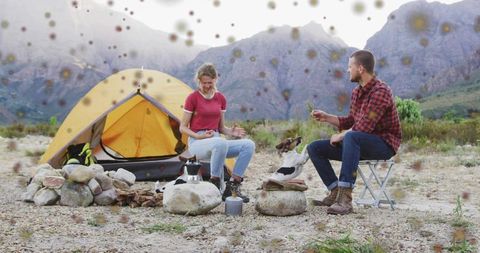 Couple Cooking with Dogs on Rustic Mountain Campsite