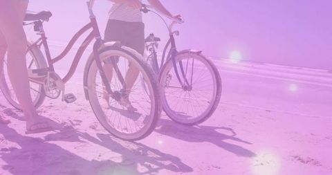 Friends enjoying beach day with cruiser bikes under summer sun