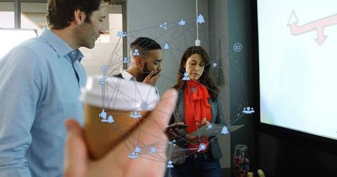 Team collaborating over presentation, holding coffee cup foreground with network overlay
