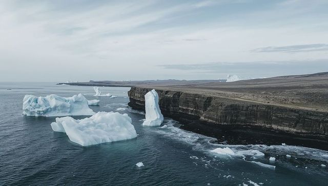 Drifting icebergs along dark stratified cliffs overcast arctic seascape with sea foam