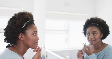 African American Woman Practicing Skincare in Home Bathroom