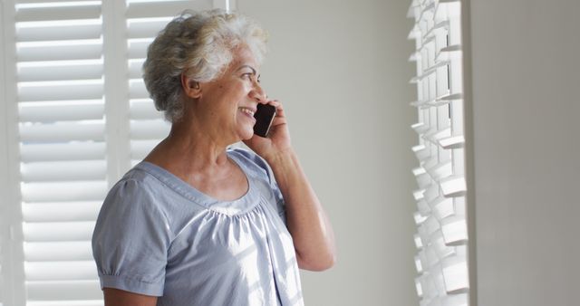 Senior Woman Talking on Mobile Phone by Window - Download Free Stock Images Pikwizard.com