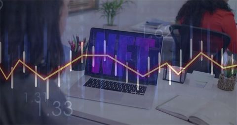 Colleagues viewing nft marketplace on laptop with candlestick graph overlay for analysis