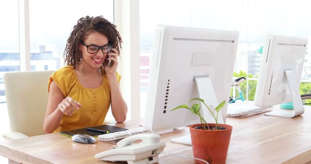 Smiling businesswoman talking on phone at modern office desk - Download Free Stock Images Pikwizard.com