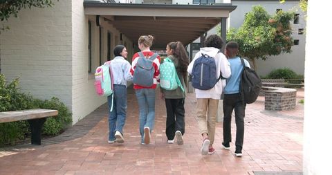 Diverse schoolchildren walking together on campus
