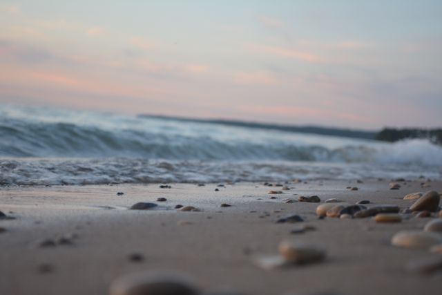 Tranquil Seashore at Sunset with Rolling Waves and Pebbles - Download Free Stock Photos Pikwizard.com
