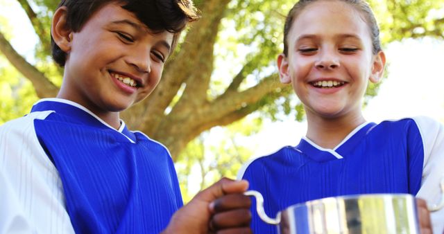 Happy Young Athletes Celebrating with Trophy Outdoors - Download Free Stock Images Pikwizard.com