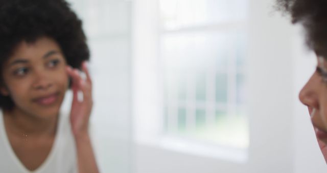 Young Woman with Curly Hair Looking at Herself in Mirror - Download Free Stock Images Pikwizard.com