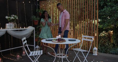 Romantic Evening: Smiling Diverse Couple by Candlelit Dinner