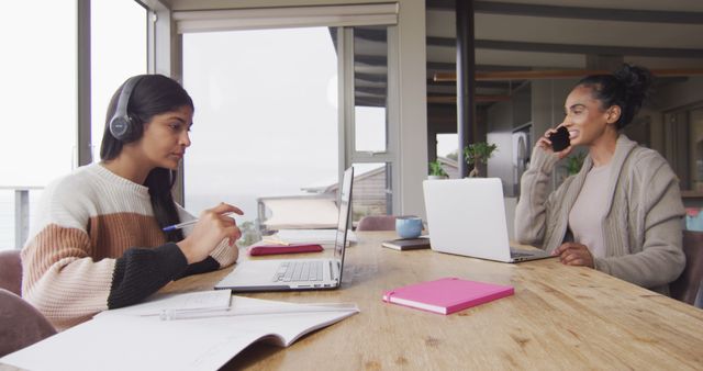 Two Women Working Remotely with Laptops at Dining Table - Download Free Stock Images Pikwizard.com