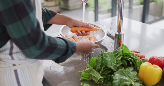 This close-up of an Asian woman washing vegetables in a kitchen sink highlights healthy lifestyle and cleanliness. Perfect for articles or advertisements focused on cooking, health, clean eating, or domestic activities. It can also be used in health and wellness blogs emphasizing the importance of food safety and preparation.