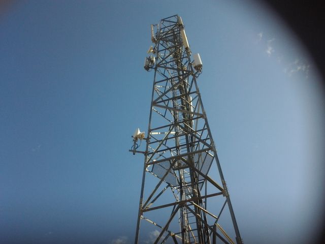 Telecommunication tower with multiple antennas under clear blue sky. Ideal for use in topics related to technology, communication infrastructure, mobile network providers, and wireless technology.