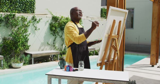 Senior Man Painting on Canvas Outdoors by Pool - Download Free Stock Images Pikwizard.com