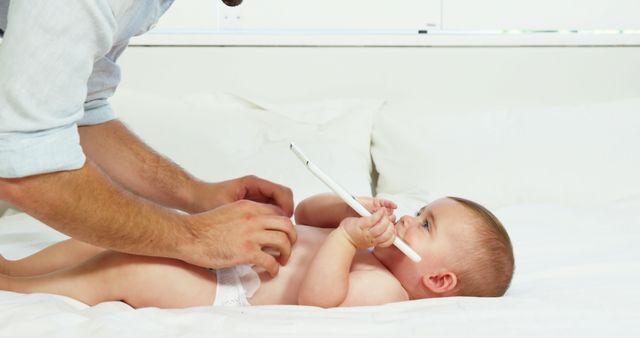 Father Changing His Baby's Diaper While Baby Playing with Pen - Download Free Stock Images Pikwizard.com