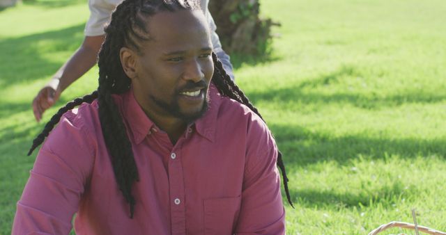 Smiling Man with Long Braids Enjoying Outdoor Picnic - Download Free Stock Images Pikwizard.com