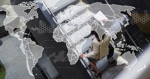 Business professionals ascending escalator holding rail with global network map overlay