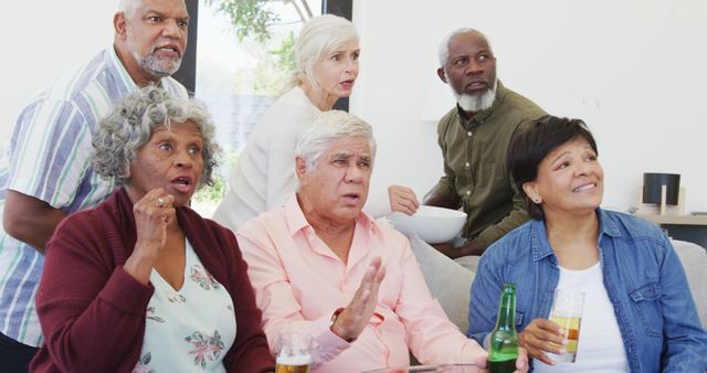 Happy senior diverse people watching tv with beer at retirement home - Download Free Stock Photos Pikwizard.com